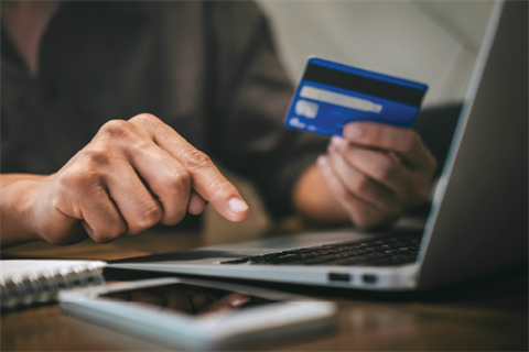 Online shopping with a credit card and laptop.