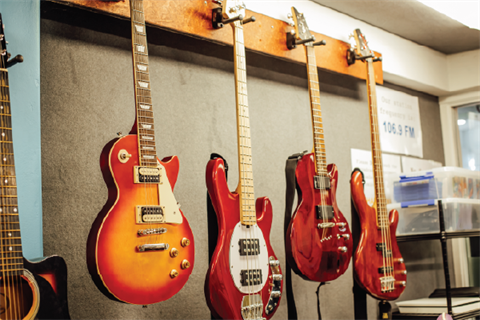 Studio guitars hanging up on the wall.